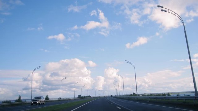 Open road with clouds and blue sky, day highway with lights