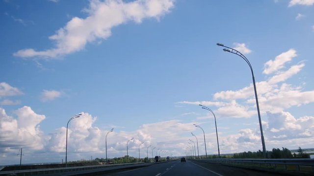 Open straight road with clouds and blue sky, day highway with lights