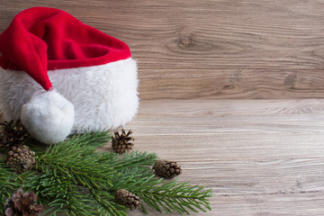 Obraz na płótnie Canvas Santa hat on Christmas tree. Wood background.