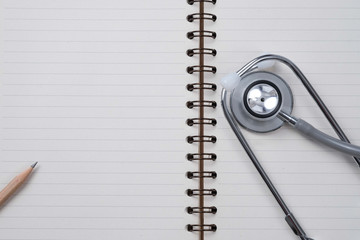 Medical concept : stethoscope on note book and pencil with wood