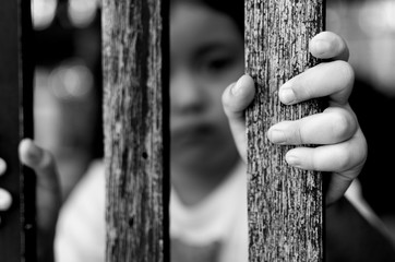 Kid with wood fence, feeling no freedom, black and white photography.