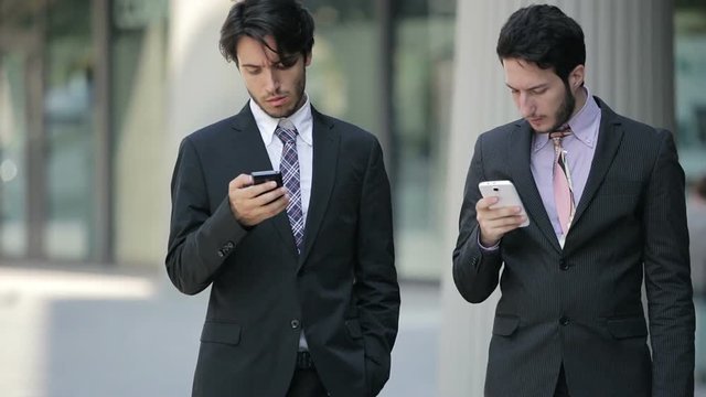 formal business people going to work and using smartphones 