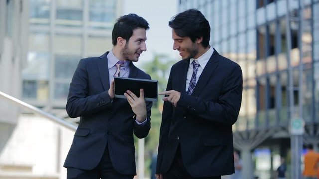 business people  debating about work on a tablet computer