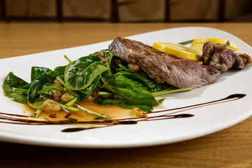 BBQ dish with spinach salad. Juicy pork steak.