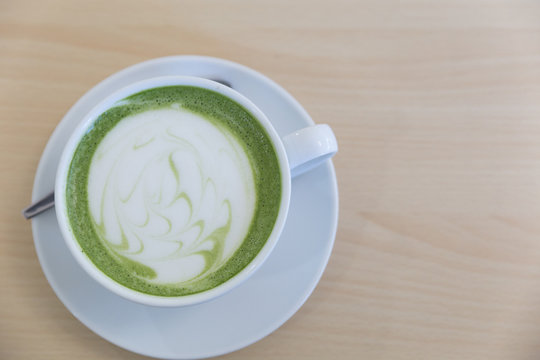 hot latte green tea on wood table