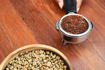 Freshly ground coffee beans in a metal filter and coffee beans for background
