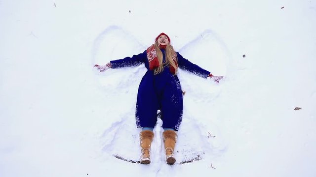 Happy woman making snow angel