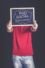 Man holding a blackboard with end social exclusion message written on it