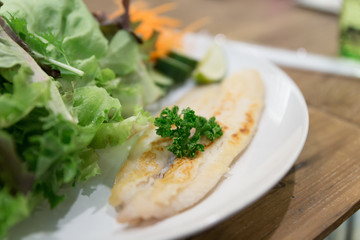 grilled fish with mixed vegetable on white plate