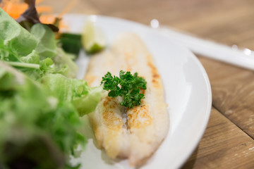 grilled fish with mixed vegetable on white plate