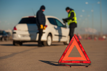 Broken car, red triangle warning sign foreground