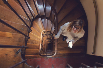 Girl using cellphone on the stairs in the building.