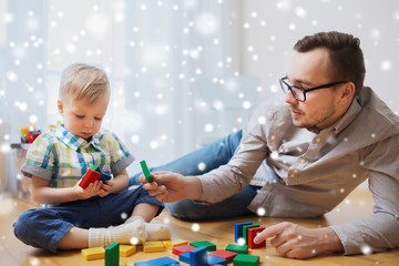 father and son playing with toy blocks at home