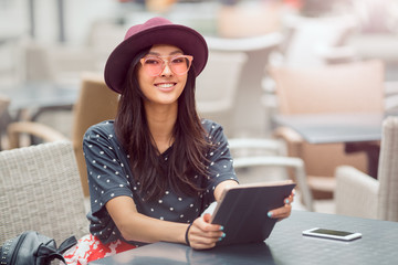 Asian young woman working with mobile phone and tablet computer in cofe shop.