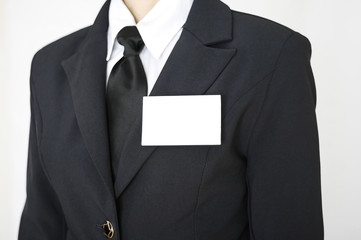 White blank name tag id business card template is attached to chest of a businessman in a black...