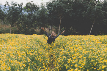 woman raise her hand up in yellow Chrysanthemum flower field, fe
