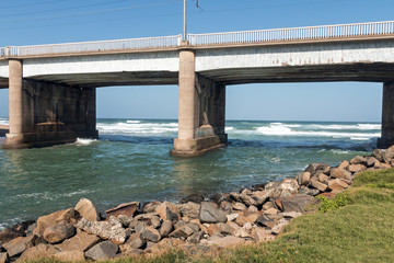 Rocky Bank and Concrete Bridge Over River Mouth