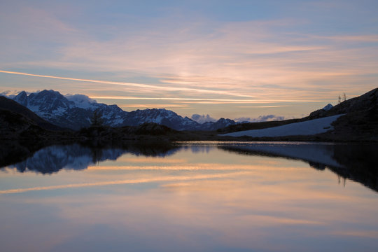Snowy peaks reflected in Lake Zana at sunrise, Malenco Valley, Valtellina, Province of Sondrio, Lombardy