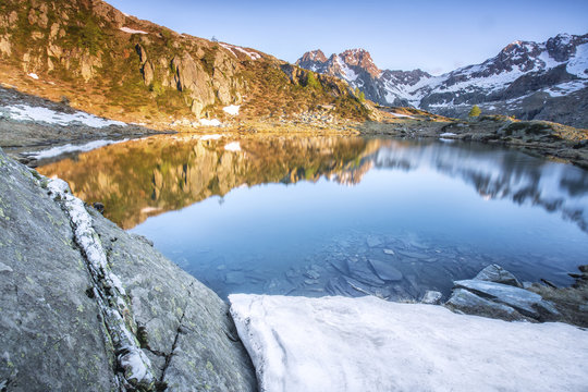 Snowy peaks reflected in Lake Zana at sunrise, Malenco Valley, Valtellina, Province of Sondrio, Lombardy