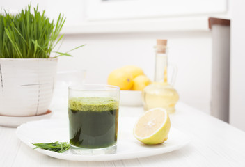 wheat grass juice on table and lemon