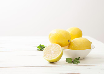 lemons and mint on white wooden table