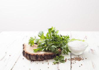 salt and coriander, parsley with seeds on a white wooden table