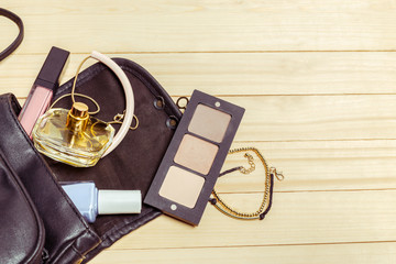 View on women bag stuff on wooden background