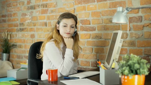 Tired woman looking to the camera while sitting in the office
