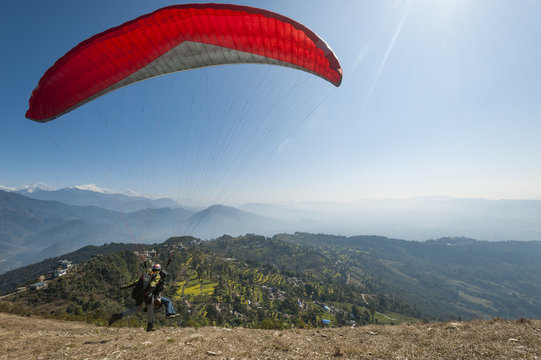 A tandem paraglider takes to the air from the top of Sarankot near Pokhara, Nepal, Himalayas