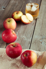 Whole and sliced apples, juice in background