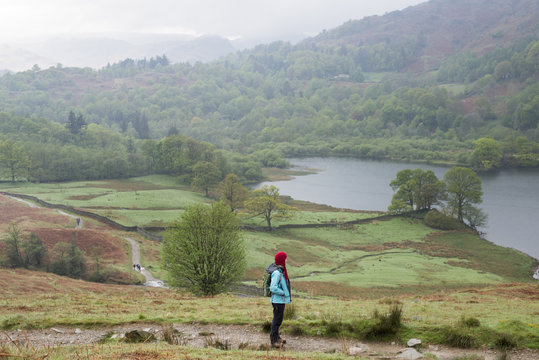A woman looks out over Rydal Water near Grasmere, Lake District National Park, Cumbria