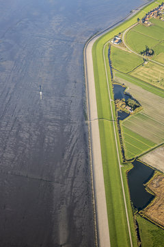 Aerial coastal view of the shore of Ameland Frisian Island with green fields, dike and sea, The Netherlands