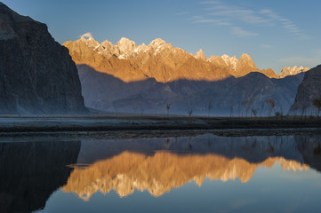 The crystal clear Shyok River creates a mirror image of sunrise on Karakoram peaks beyond the Khapalu valley near Skardu, Gilgit-Baltistan, Pakistan