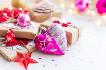 Christmas and New Year background with presents and decorative heart for Christmas tree. Holiday background with stars confetti and light bulbs. Place for text.