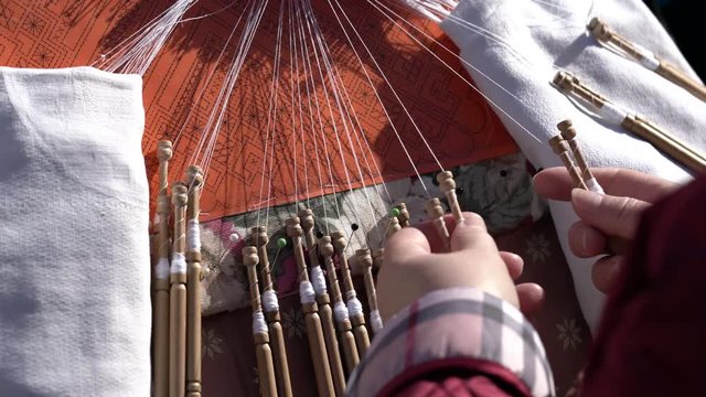 Mujer trabajando en encaje de bolillos en una feria de artesan&iacute;a tradicional espa&ntilde;ola