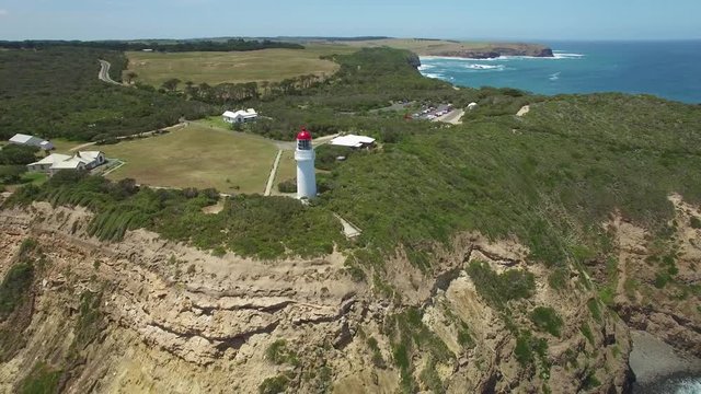 Flying away from Cape Schanck Lighthouse over rugged coastline into open ocean. Mornington Peninsula, Melbourne, Australia.