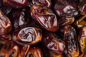 Date fruit closeup background. Heap of dried shiny brown red date fruit. Top view.