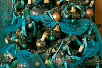 Naklejka premium Green New Year tree decorated with toys and balls. Christmas background with grunge plaster wall