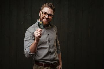 Man holding credit card in hand and looking at camera