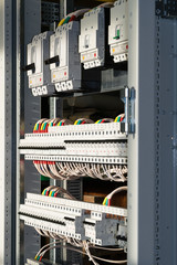 Connecting cables with cable lugs to circuit breakers in the electrical control panel on the artboard. Alignment of the components to ensure safety and reliability.