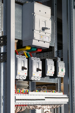 Connecting cables with cable lugs to circuit breakers in the electrical control panel on the artboard. Alignment of the components to ensure safety and reliability.