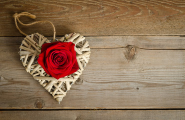 wicker heart handmade with bud of red rose