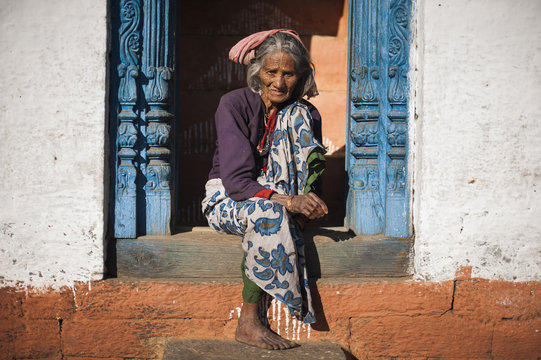 A old woman sits outside her house in Uttarakhand