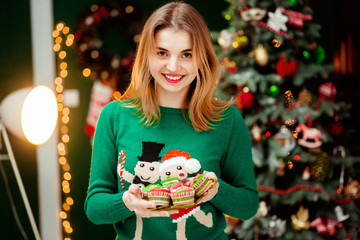 young and beautiful woman in cute green sweater holding plate wi