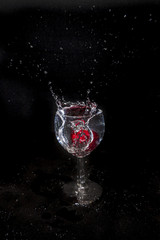 radish splashing in wine glass isolated on black background