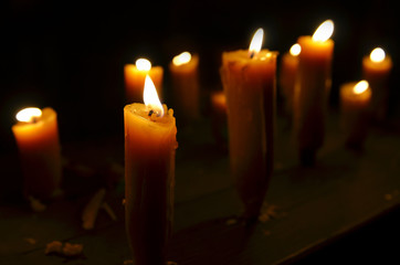 Antique candle burning in a dark room. Christmas Eve, divination, yuletide. Christmas backgrounds. holiday rituals, religion, spirituality, zen. space for text, close-up, copy space