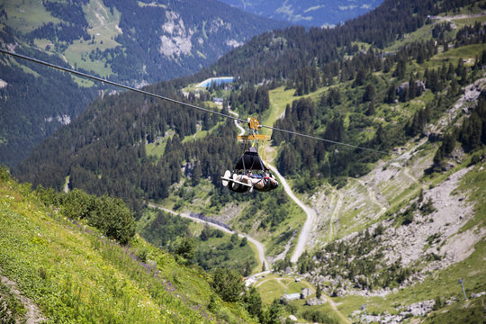 Man going for an extreme Zip-line flight over the alpine landscape in summer, Alps mountain massif, Cantons Vaud and Valais, Swiss Alps, Switzerland