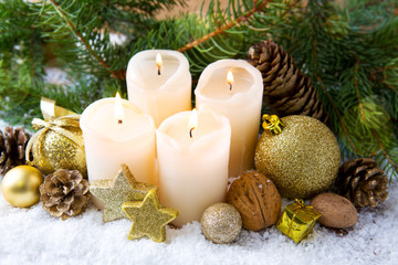 Four burning advent candles and Christmas decoration.
