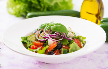 Greek salad with fresh tomato, cucumber, red onion, basil, lettuce, feta cheese, black olives and Italian herbs