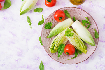 Fresh and healthy Chicory (witloof) Salad and tomato on a plate. Dietary menu. Healthy food. Top view